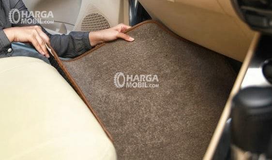 gambar seorang sedang mengecek dan melakukan perawatan karpet dalam mobilnya