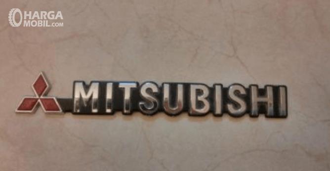 Gambar ini menunjukkan logo warna merah dan tulisan Mitsubishi