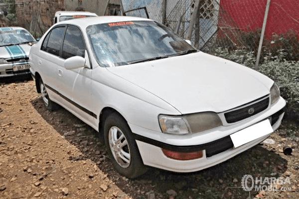 Gambar ini menunjukkan mobil Toyota Corona 1993 warna putih tampak depan