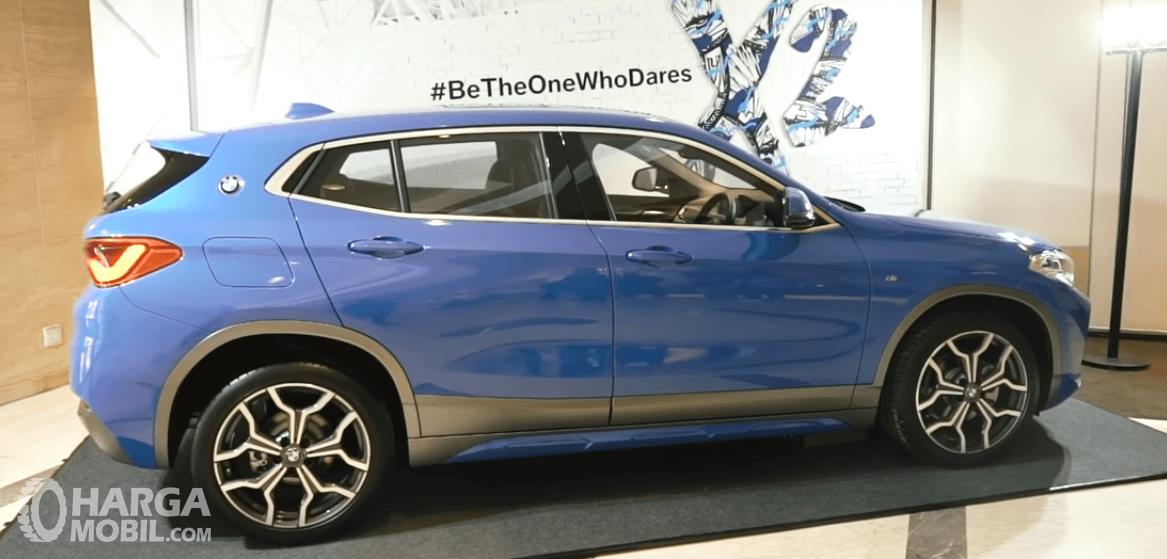 Gambar ini menunjukkan mobil BMW X2 warna biru tampak bagian samping