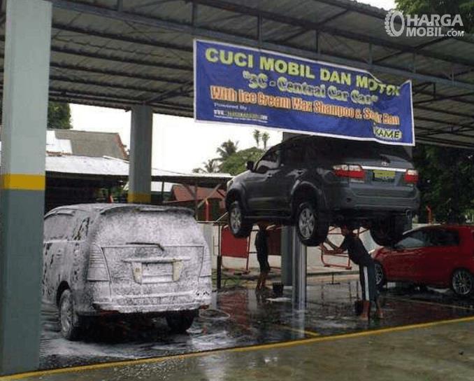 Gambar ini menunjukkan beberapa mobil sedang dicuci mobil